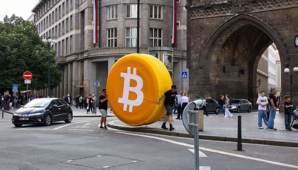 Ein großes Bitcoin-Logo in einer geschäftigen Stadt